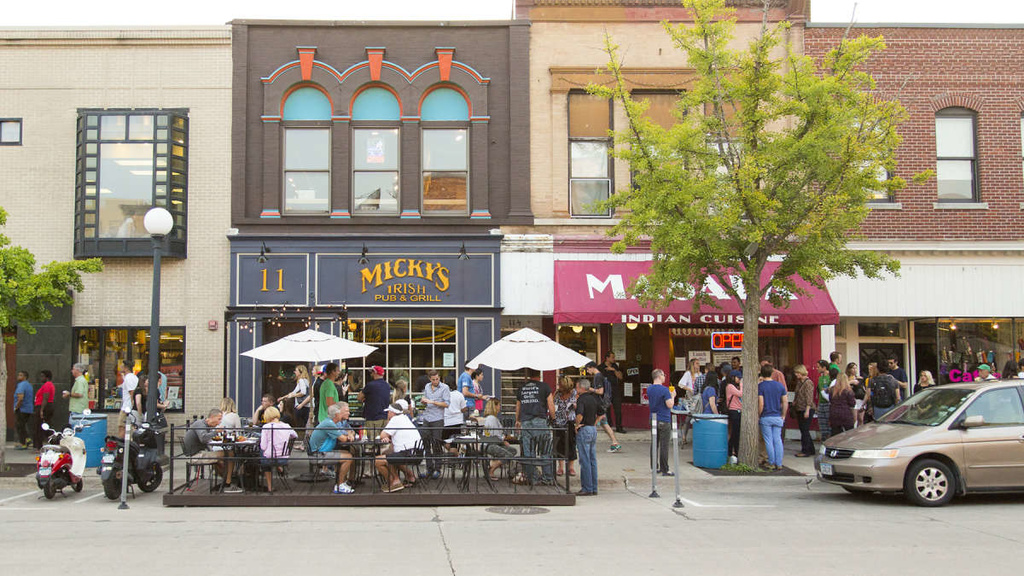 Downtown Iowa City with many people eating in outside dining areas and talking